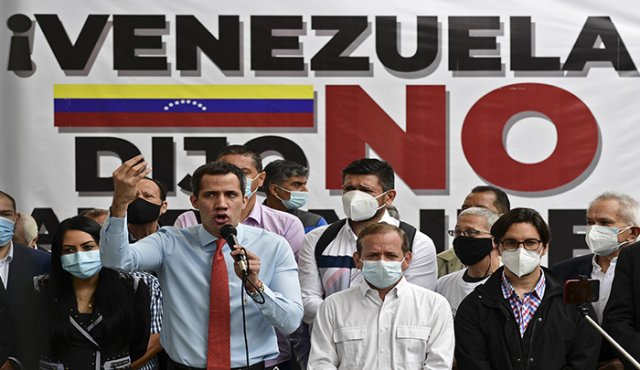 El líder opositor venezolano Juan Guaido hace gestos mientras habla durante una conferencia de prensa frente a un cartel que dice “Venezuela dijo no al fraude”, en el que anunció el lanzamiento de una consulta popular virtual para ignorar las últimas elecciones legislativas en Caracas. AFP