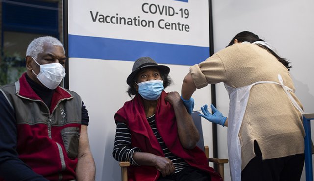Una pareja de ancianos recibe la primera de dos vacunas Pfizer / BioNTech COVID.19. AFP