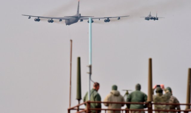 Soldados estadounidenses ven un avión estadounidense B-52 Stratofortress, escoltado por un F-15K caza que vuela sobre la Base Osan en Pyeongtaek, al sur de Seúl. AFP