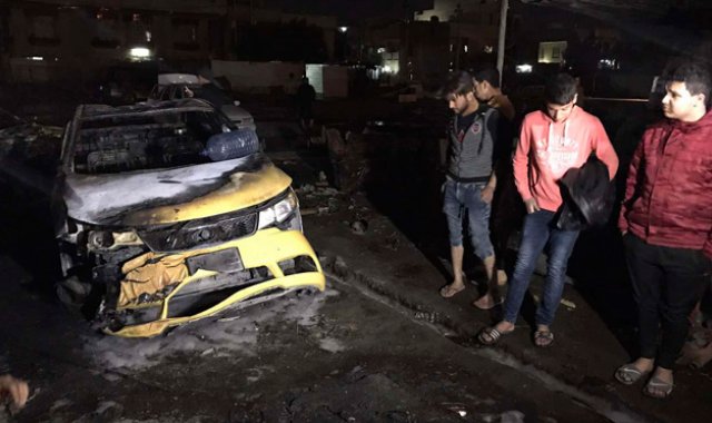 Unas personas observan la zona donde un coche bomba explotó en el vecindario Al-Bayaa, de Bagdad, la capital iraquí, dejando decenas de muertos y heridos. AP