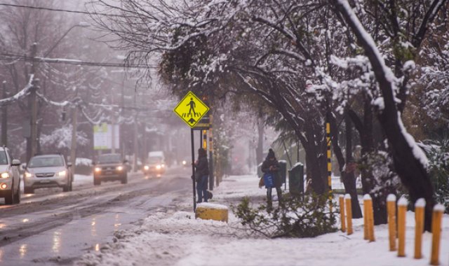 Una inusual nevada sorprendió a los habitantes de Santiago, la capital chilena, causando unos cuantos cortes de energía y pequeños atascos de tráfico, en las zonas orientales de la capital, la más cercana a la cordillera de los Andes.  AFP