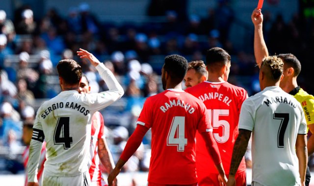 El defensor español del Real Madrid, Sergio Ramos (izquierda) reacciona cuando el árbitro español Guillermo Cuadra Fernández le muestra una tarjeta roja durante el partido contra Girona. AFP