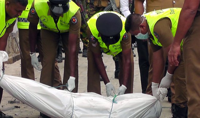 Los policías se preparan para retirar el cuerpo de unos los terroristas abatidos en Kalmunai. AFP