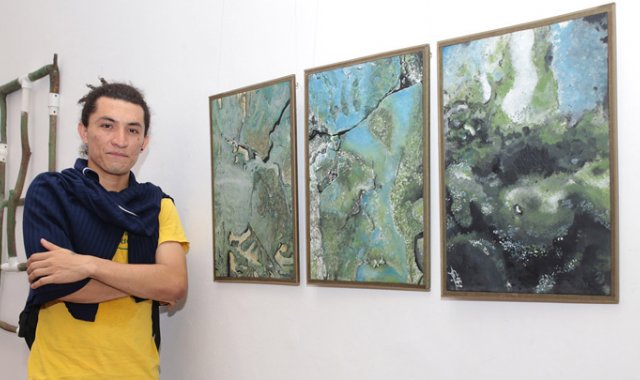 ‘Humedad’, tríptico inspirado en la vida microscópica, fue la obra ganadora en la categoría de pintura. Su creador, Jhorman Albeiro Tariba García, de 24 años, dijo que pintó sobre madera extraída de una puerta destruida por la humedad. César Obando/La Opinión