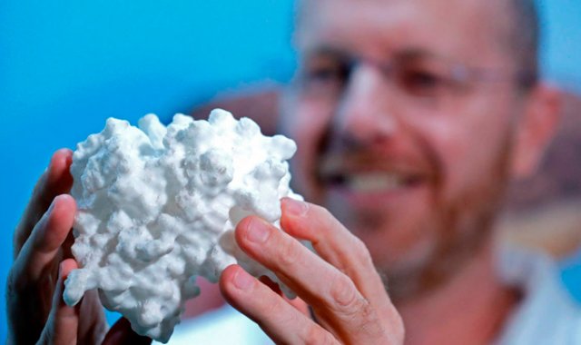 El científico israelí Ilan Samish, fundador de la compañía Amai, exhibe una muestra de una proteína que desarrolló. AFP