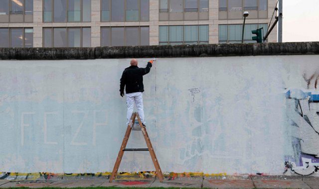 Los berlineses de uno y otro lado escalaron el Muro ante la Puerta de Brandeburgo, símbolo de la división de la ciudad. Algunos sacaron los primeros martillos para destruir la construcción de cemento de 160 kilómetros de largo. AFP