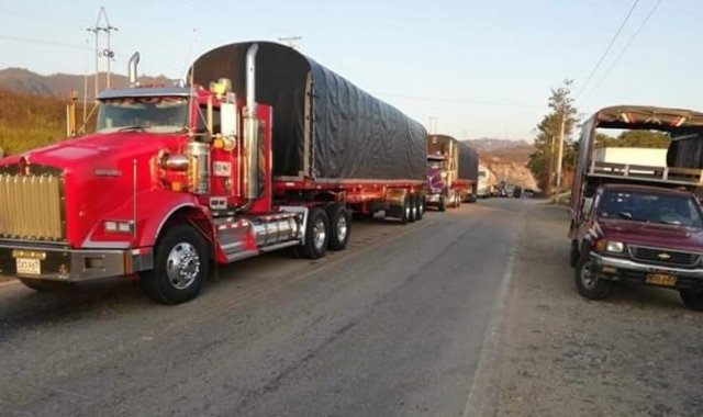 Se puede observar una fila de vehículos en la carretera y muchos residentes están a la espera de poder desplazarse. Cortesía