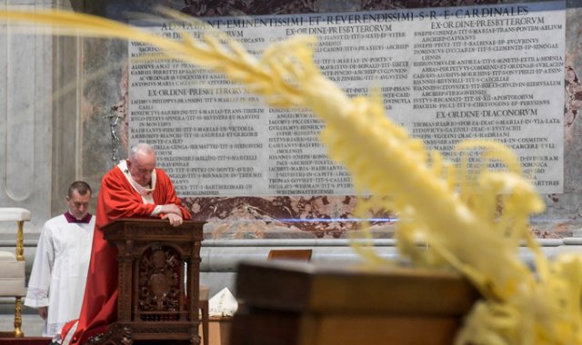 El papa Francisco rezando durante la misa del Domingo de Ramos, a puertas cerradas en la Basílica de San Pedro en el Vaticano. AFP