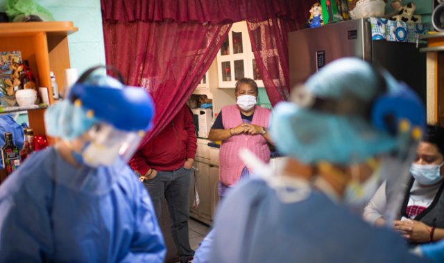 Trabajadores de la salud ingresan a una casa durante una visita puerta a puerta para llevar a cabo las pruebas COVID-19 en la Ciudad de México. AFP