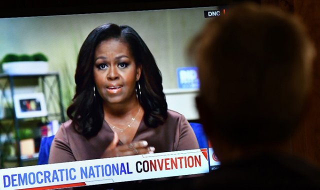 Una persona observa a la ex primera dama Michelle Obama hablar durante la noche de apertura de la Convención Nacional Demócrata, la noche del lunes. AFP