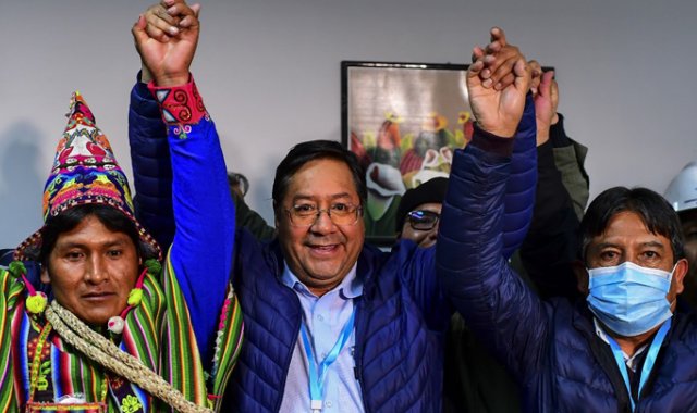 El candidato presidencial izquierdista de Bolivia Luis Arce (centro), del partido Movimiento por el Socialismo, celebra con su compañero de fórmula David Choquehuanca (derecha). AFP