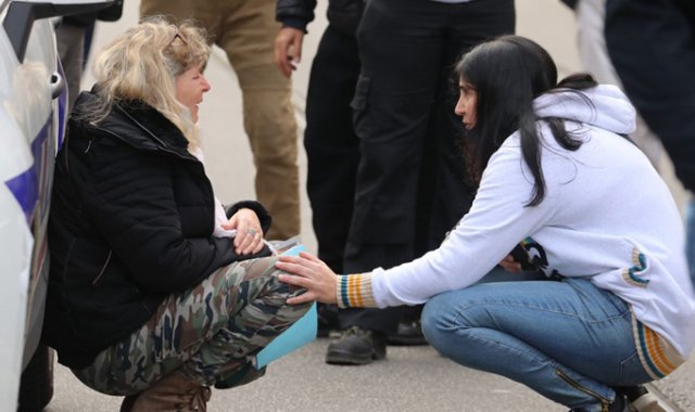 Una mujer se arrodilla junto a un carro de la Policía mientras llora, después de un ataque con cuchillo en Niza. AFP